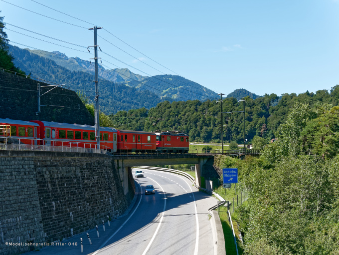 Reginalexpress der RhB überquert die Autostraße Richtung Disentis